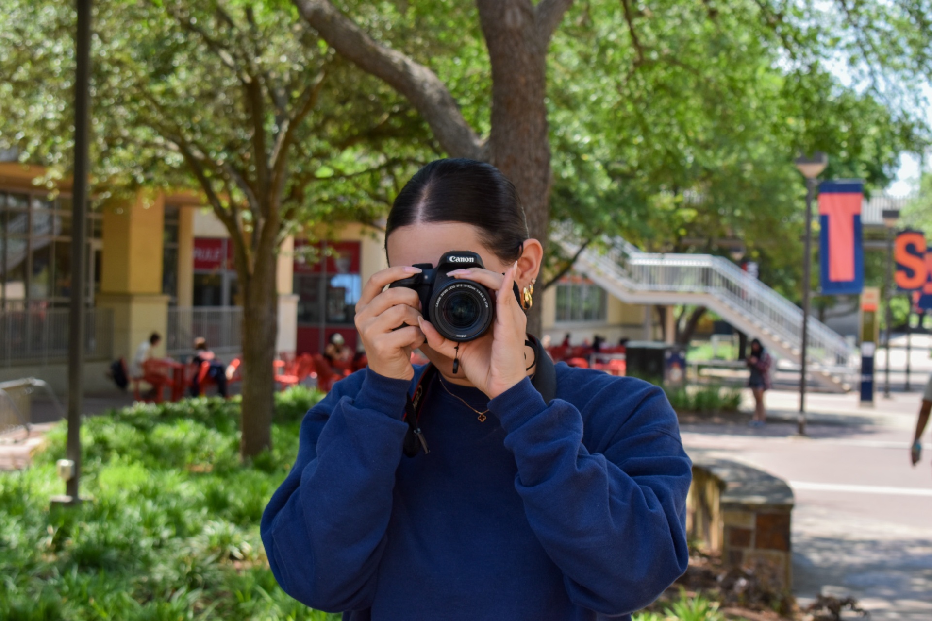 Cristina holding a Canon camera, taking a photo